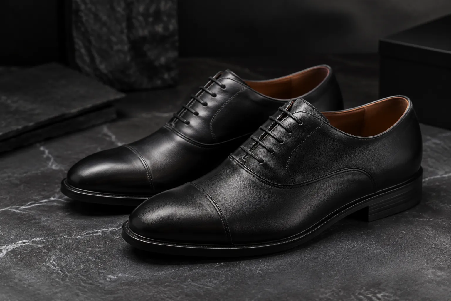 Premium men's black leather Oxford shoes on a stone surface